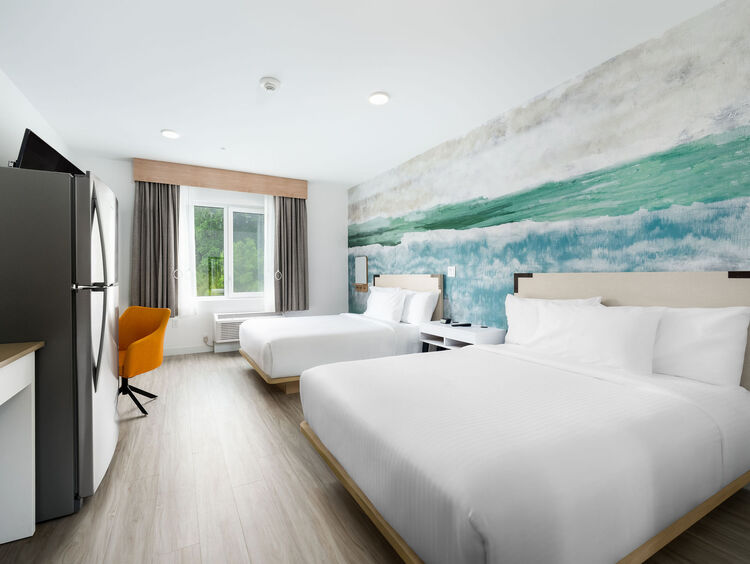 Double Queen ADA with two queen beds, a work desk, kitchen & in-suite laundry